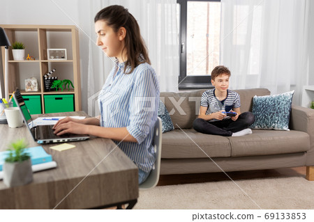 boy with gamepad playing video game at home 69133853