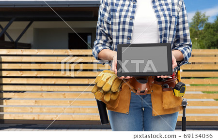 woman builder with working tools showing tablet pc 69134036