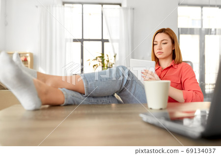 woman with notebook and laptop at home office 69134037