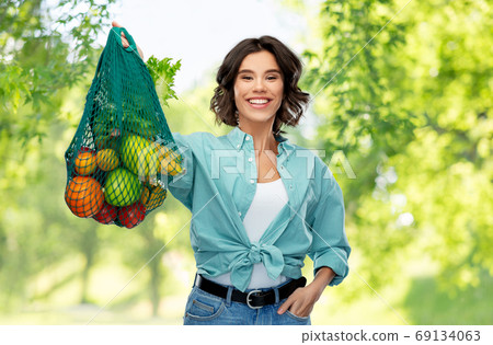 happy smiling woman with food in reusable net bag happy smiling woman with food in reusable net bag 69134063