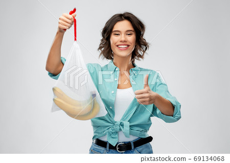 happy woman with bananas in reusable string bag happy woman with bananas in reusable string bag 69134068