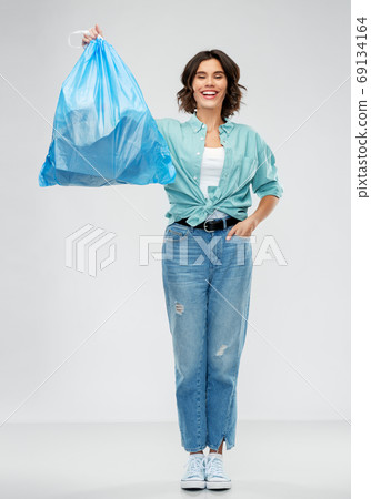 smiling woman holding plastic trash bag with waste smiling woman holding plastic trash bag with waste 69134164