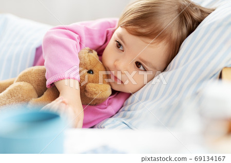little girl lying in bed at home 69134167