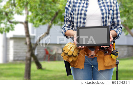 woman builder with working tools showing tablet pc 69134254
