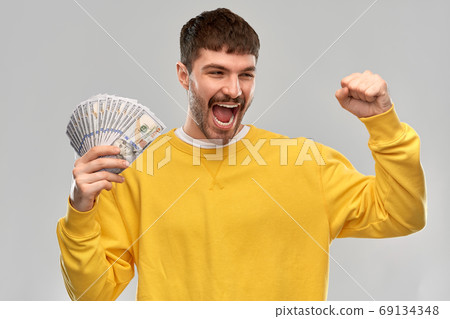 happy young man with money celebrating success happy young man with money celebrating success 69134348