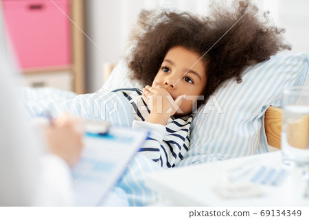 doctor with clipboard and sick girl in bed at home 69134349