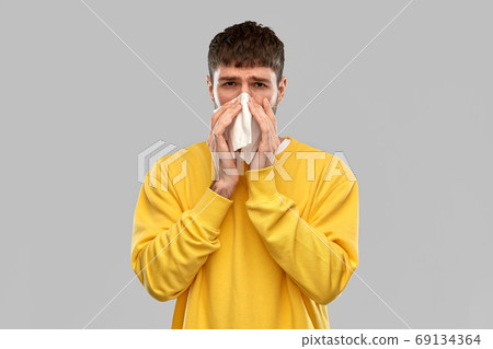 man with paper napkin blowing nose man with paper napkin blowing nose 69134364