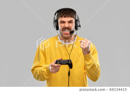 man with headset and gamepad playing video game man with headset and gamepad playing video game 69134415
