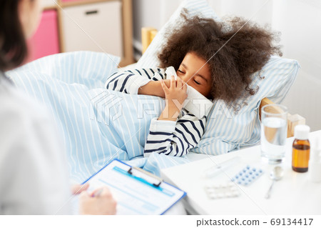 doctor and sick girl in bed blowing nose doctor and sick girl in bed blowing nose 69134417