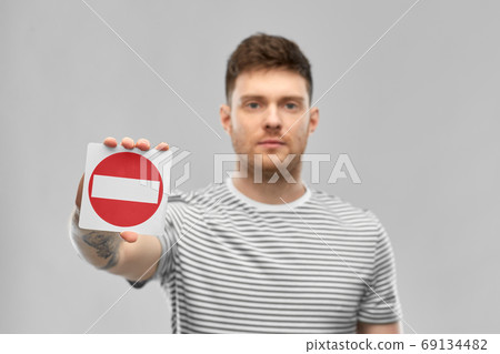 young man showing stop sign 69134482
