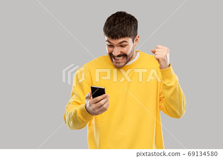 happy smiling young man with smartphone 69134580