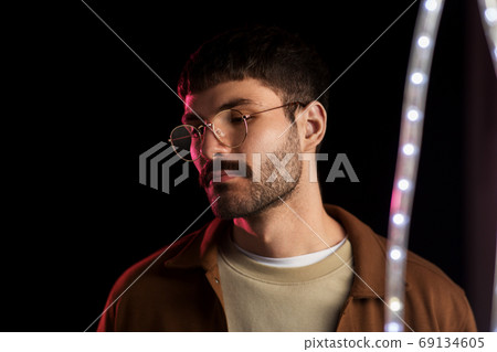 man in glasses over neon lights at nightclub man in glasses over neon lights at nightclub 69134605