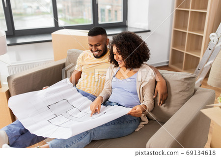 couple with boxes and blueprint moving to new home couple with boxes and blueprint moving to new home 69134618