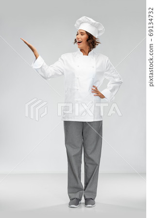 smiling female chef holding something on hand 69134732