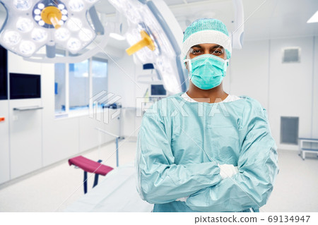 indian male doctor or surgeon over operating room indian male doctor or surgeon over operating room 69134947