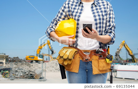 woman or builder with phone and working tools 69135044