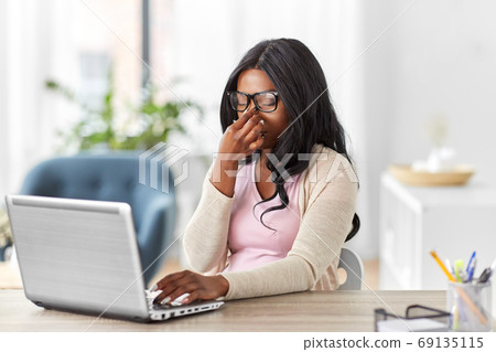 tired woman with laptop working at home office 69135115