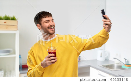 happy man with smartphone and juice taking selfie 69135148