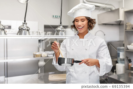 happy smiling female chef with saucepan 69135394