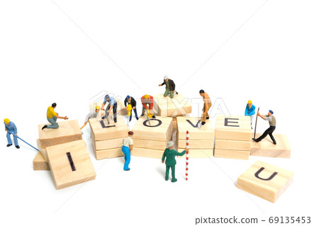 Miniature people : Worker team building word " Love " on wooden block with white background  69135453