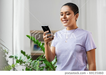 african american woman with smartphone at home 69135860