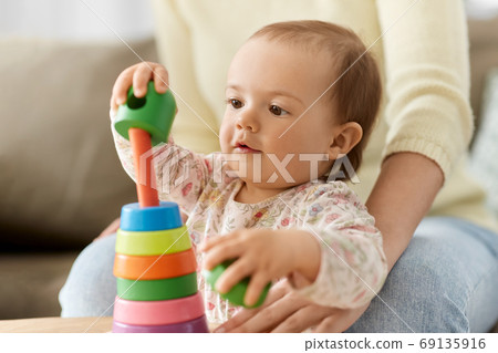 lovely baby girl playing with toy pyramid at home 69135916