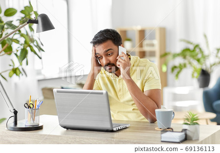 man calling on smartphone at home office 69136113
