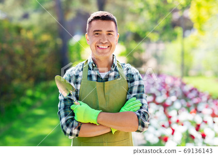 happy man in apron with scoop at summer garden 69136143