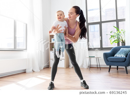 happy mother with little baby exercising at home happy mother with little baby exercising at home 69136245