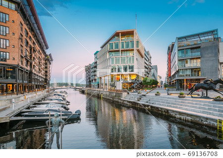 Oslo, Norway. View Of Residential Multi-storey Houses In Aker Brygge District In Summer Evening. Famous And Popular Place. Pier Jetty With Boats. Oslo, Norway. View Of Residential Multi-storey Houses In Aker Brygge District In Summer Evening. Famous And Popular Place. Pier Jetty With Boats. 69136708