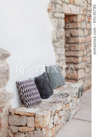 Geometric pillows near a wall in a garden Geometric pillows near a wall in a garden 69136780