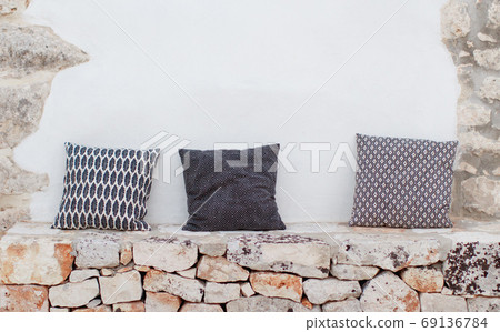 Geometric pillows near a wallon a patio Geometric pillows near a wallon a patio 69136784