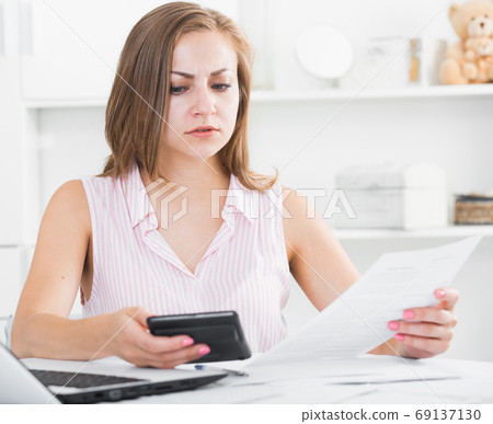 Upset girl looking at papers Upset girl looking at papers 69137130