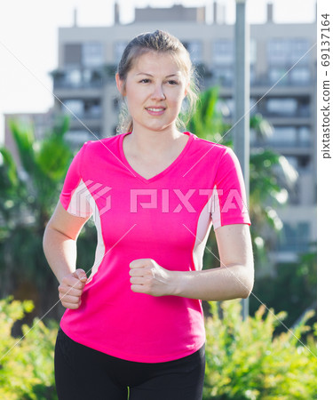 Girl in pink T-shirt is jogging Girl in pink T-shirt is jogging 69137164