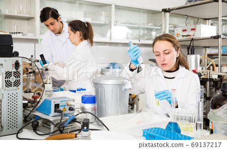 Female chemist mixing reagents Female chemist mixing reagents 69137217