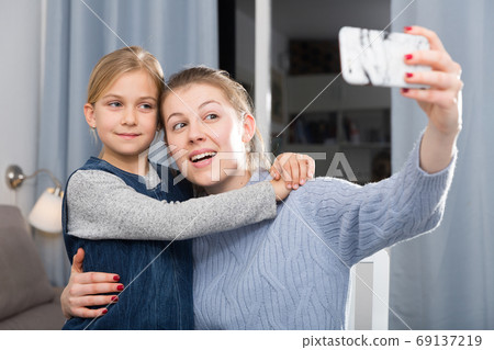 Girl and her mother taking selfie Girl and her mother taking selfie 69137219