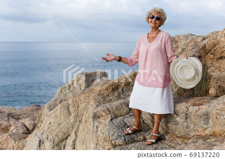 Senior woman relaxing at seaside Senior woman relaxing at seaside 69137220