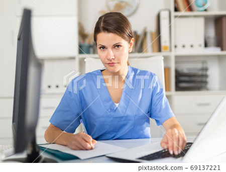 Focused woman physician listening to patient complaints at clinic Focused woman physician listening to patient complaints at clinic 69137221