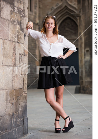 smiling female standing near the stone wall smiling female standing near the stone wall 69137223