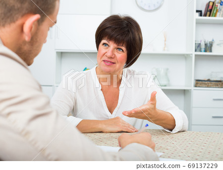 Employer discusses with elderly woman Employer discusses with elderly woman 69137229