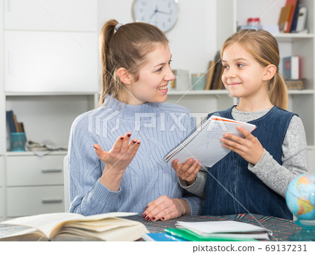 Woman helping her daughter with hometask Woman helping her daughter with hometask 69137231