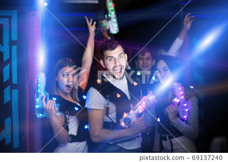 Young people in colorful beams on lasertag arena 69137240