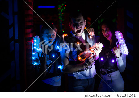 Young people with laser guns on lasertag arena Young people with laser guns on lasertag arena 69137241