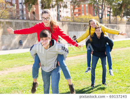 Happy teens compete with each other in park 69137243