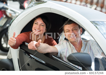 Couple standing near twizy electric 69137244