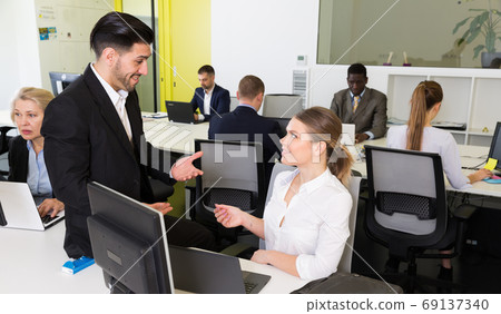 Man flirting with woman in co-working space Man flirting with woman in co-working space 69137340
