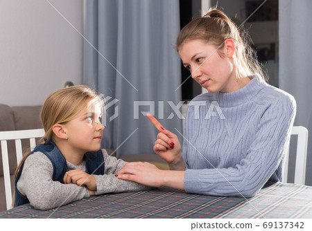 Woman scolding her daughter Woman scolding her daughter 69137342