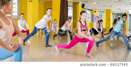 Tweens exercising with coach in choreography class Tweens exercising with coach in choreography class 69137345