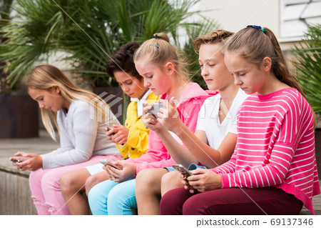 Five kids are playing on phone Five kids are playing on phone 69137346