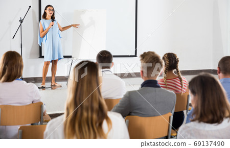 Female student answering in front of student group Female student answering in front of student group 69137490
